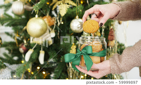 Oat cookies in a glass jar. Against the background of Christmas decor Oat cookies in a glass jar. Against the background of Christmas decor 59999897