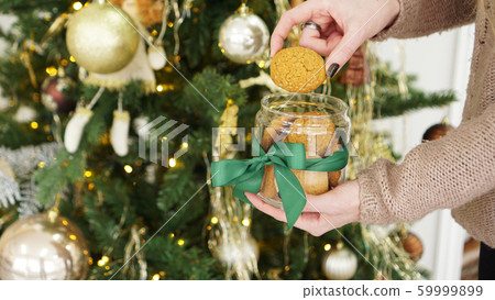 Oat cookies in a glass jar. Against the background of Christmas decor Oat cookies in a glass jar. Against the background of Christmas decor 59999899