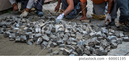 Team Of Construction Workers Building Pavement With Cobblestones 60001195