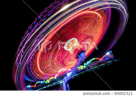 Colorful Light Trail From A Fast Carrousel At A Fun Park In The NIght 60002321