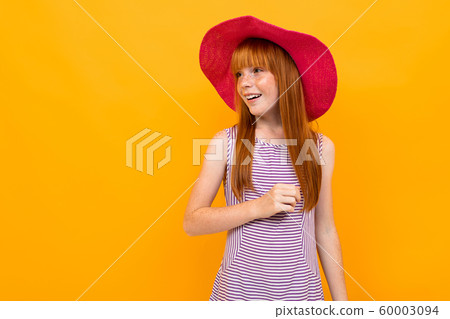 European girl in a red panama on a yellow background European girl in a red panama on a yellow background 60003094