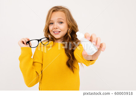 girl holds eye drops and glasses on a white studio background girl holds eye drops and glasses on a white studio background 60003918