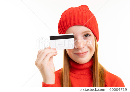 red-haired girl holding a credit card in front of a white background red-haired girl holding a credit card in front of a white background 60004719