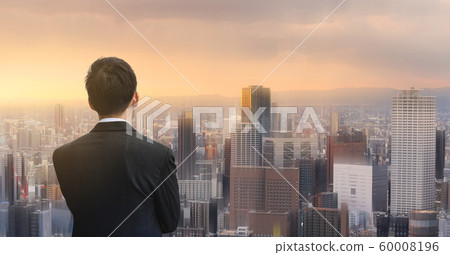 Businessman looking at futuristic city in sunset. Business concept Businessman looking at futuristic city in sunset. Business concept 60008196