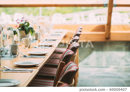 Cozy Interior Of Summer Cafe. Table And Cutlery Laid Out Cozy Interior Of Summer Cafe. Table And Cutlery Laid Out 60009407