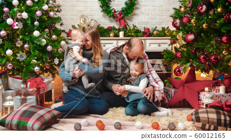 Happy successful family sits in the Christmas setting Happy successful family sits in the Christmas setting 60012165