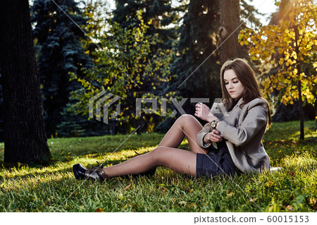 A young woman with long hair and in a woolen coat A young woman with long hair and in a woolen coat 60015153