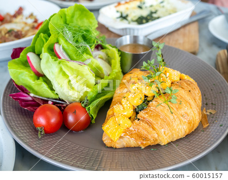 Warm cooked croissant with spinach inside topping with cream cheese, served with vegetable salad Warm cooked croissant with spinach inside topping with cream cheese, served with vegetable salad 60015157