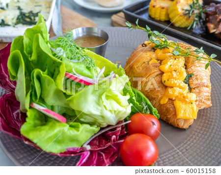 Warm cooked croissant with spinach inside topping with cream cheese, served with vegetable salad Warm cooked croissant with spinach inside topping with cream cheese, served with vegetable salad 60015158