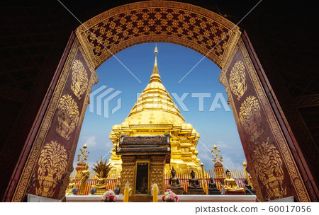 golden pagoda view through from ancient door architrave arch at Wat Phra That Doi Suthep temple. popular famous tourist temple attraction landmark in Chiangmai, Thailand golden pagoda view through from ancient door architrave arch at Wat Phra That Doi Suthep temple. popular famous tourist temple attraction landmark in Chiangmai, Thailand 60017056