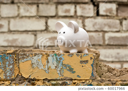 Piggy bank on the wall of dismantled building 60017966