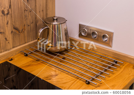 Modern chrome kettle on the kitchen table. 60018056