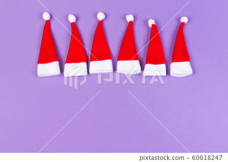 Top view red Santa hats on colorful background. 60018247