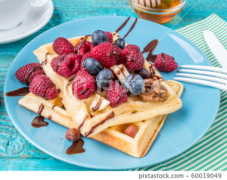 Homemade waffles with raspberries and blueberry Homemade waffles with raspberries and blueberry 60019049