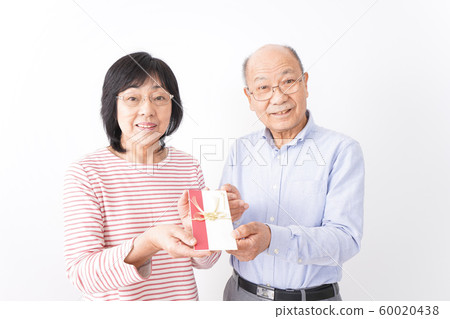 Senior couple handing over celebration 60020438