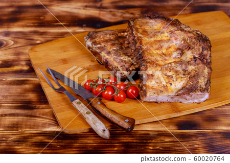 Hot meat dishes pork ribs with tomatoes on an old rustic board Hot meat dishes pork ribs with tomatoes on an old rustic board 60020764