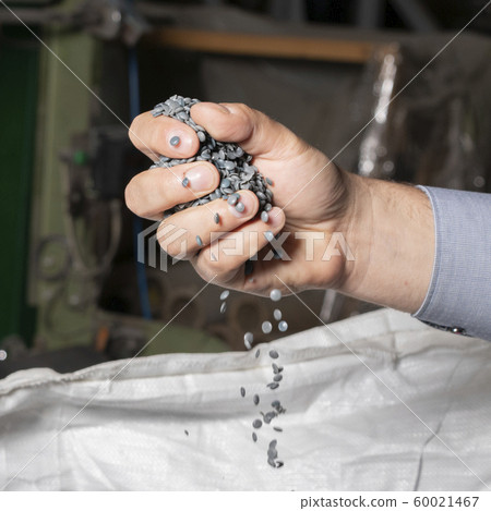 Gray granules of recycled plastic trash in the 60021467