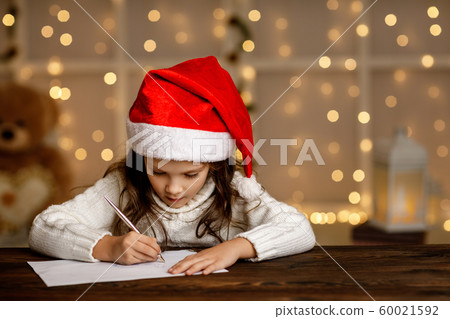 child girl in santa hat writing letter to Santa Claus child girl in santa hat writing letter to Santa Claus 60021592