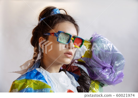 Woman addicted of sales and clothes, wearing plastic, recycling concept Woman addicted of sales and clothes, wearing plastic, recycling concept 60021974