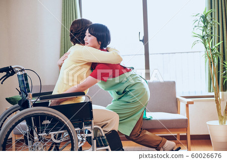 Wheelchair woman and helper Wheelchair woman and helper 60026676