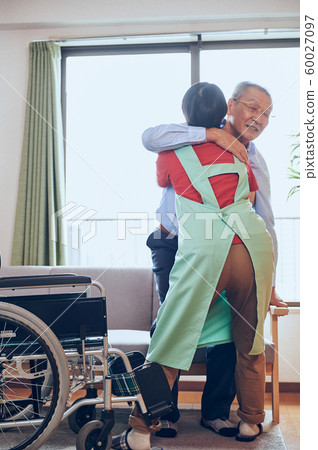 Wheelchair man and helper Wheelchair man and helper 60027097