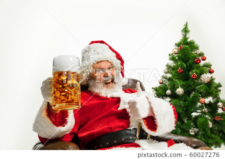 Santa Claus drinking beer near Christmas tree, congratulating of New Year 2020 Santa Claus drinking beer near Christmas tree, congratulating of New Year 2020 60027276