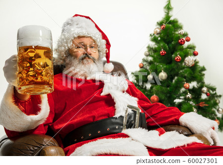 Santa Claus drinking beer near Christmas tree, congratulating of New Year 2020 60027301
