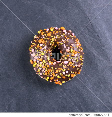 fresh donut with toppings on a dark background fresh donut with toppings on a dark background 60027881