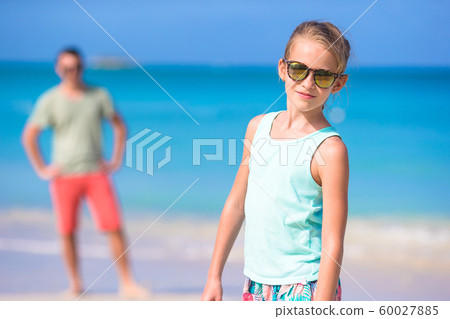 Little girl and happy dad having fun during beach vacation Little girl and happy dad having fun during beach vacation 60027885