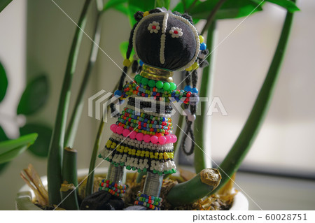 Souvenir from South Africa, doll in a traditional national dress made of beads. Horizontal image 60028751