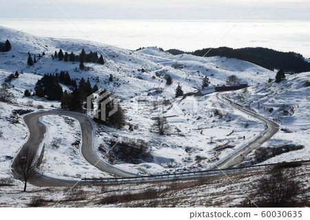 Mountain road with curves in winter season Mountain road with curves in winter season 60030635
