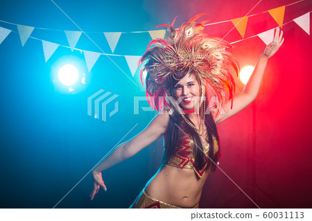 Carnival, belly dance and holiday concept - Beautiful female samba dancer wearing gold costume and smiling 60031113