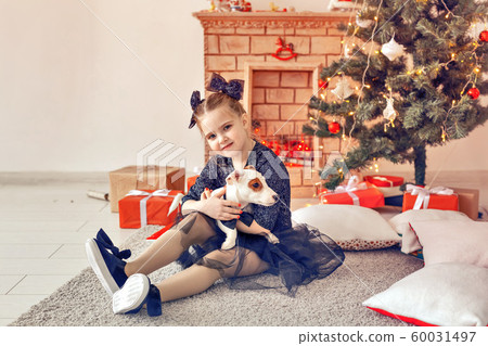 Holidays and childhood concept - Portrait of little happy cute child girl and puppy with Christmas present Holidays and childhood concept - Portrait of little happy cute child girl and puppy with Christmas present 60031497