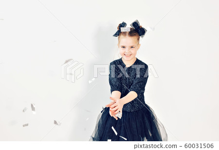 Party, holidays, new year and celebration concept - Female child throwing confetti. 60031506