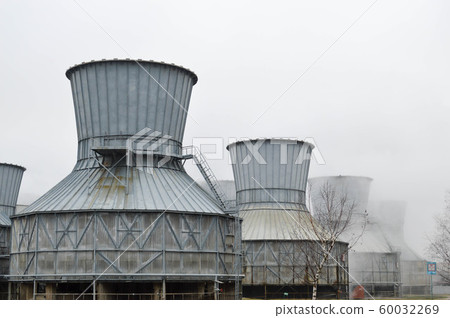 Large cooling towers in water and fog at an oil  60032269