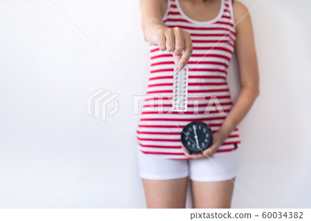 Woman hands holding birth control pill and clock,Concept for contraceptive,Copy space for text on white background 60034382