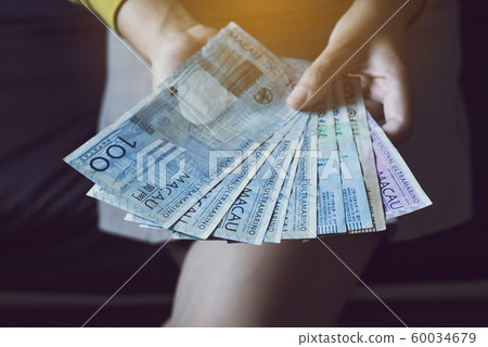 Hands woman counting one hundred macau banknotes,Close up Hands woman counting one hundred macau banknotes,Close up 60034679