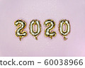 Happy New year 2020 celebration. Gold foil balloons numeral 2020 and golden stars on pastel pink 60038966