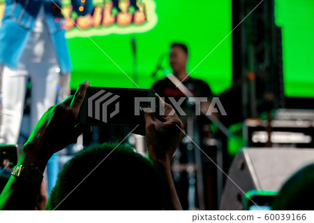 People use mobile phones to live or take pictures People use mobile phones to live or take pictures 60039166
