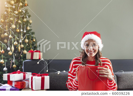 Woman opening Christmas gift 60039226