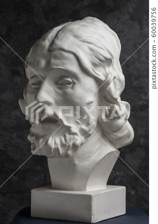 Gypsum copy of ancient statue John the Baptist head on dark textured background. Plaster sculpture man face. Gypsum copy of ancient statue John the Baptist head on dark textured background. Plaster sculpture man face. 60039756