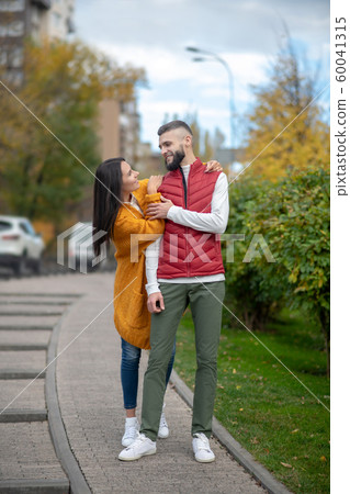 Positive delighted couple having a walk on the street Positive delighted couple having a walk on the street 60041315