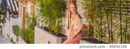 Young woman tourist in Bukchon Hanok Village is one of the famous place for Korean traditional Young woman tourist in Bukchon Hanok Village is one of the famous place for Korean traditional 60042180