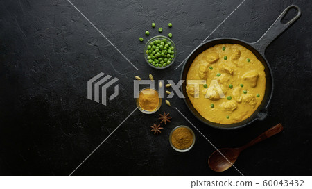 Cooking tasty chicken curry in pan on black background. Flat lay, top view with copy space Cooking tasty chicken curry in pan on black background. Flat lay, top view with copy space 60043432