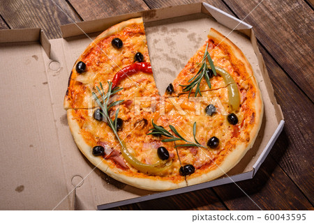 Tasty fresh hot pizza against a dark background Tasty fresh hot pizza against a dark background 60043595