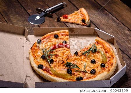 Tasty fresh hot pizza against a dark background Tasty fresh hot pizza against a dark background 60043599