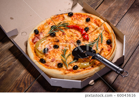 Tasty fresh hot pizza against a dark background Tasty fresh hot pizza against a dark background 60043616