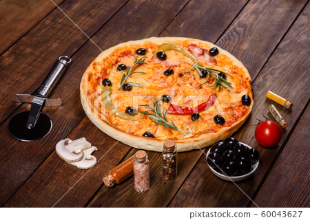 Tasty fresh hot pizza against a dark background Tasty fresh hot pizza against a dark background 60043627