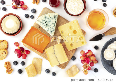 Cheese platter, a flat lay top shot on a white background. Blue cheese, red Leicester, Emmental, goat cheese, Brie and others with wine, fruits, nuts Cheese platter, a flat lay top shot on a white background. Blue cheese, red Leicester, Emmental, goat cheese, Brie and others with wine, fruits, nuts 60043948