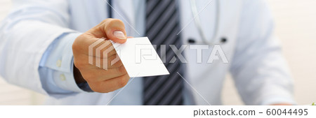 Male physician hand holding and giving white blank calling card 60044495